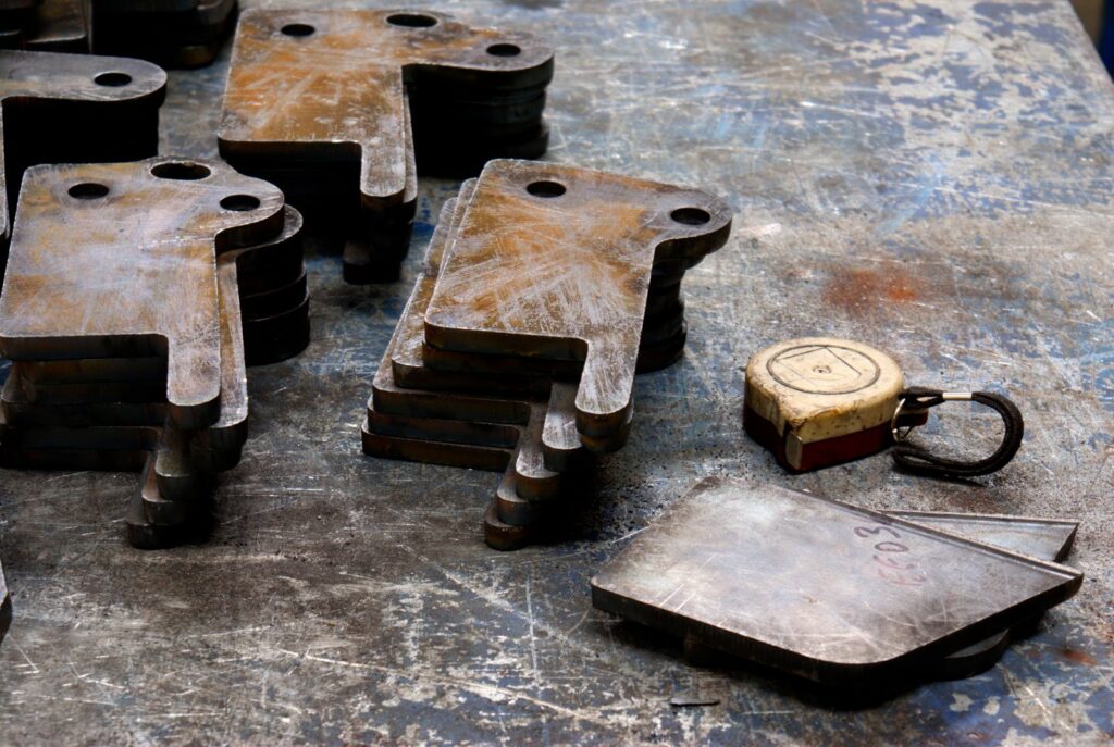 Stacks of finished laser-cut metal parts on a workbench
