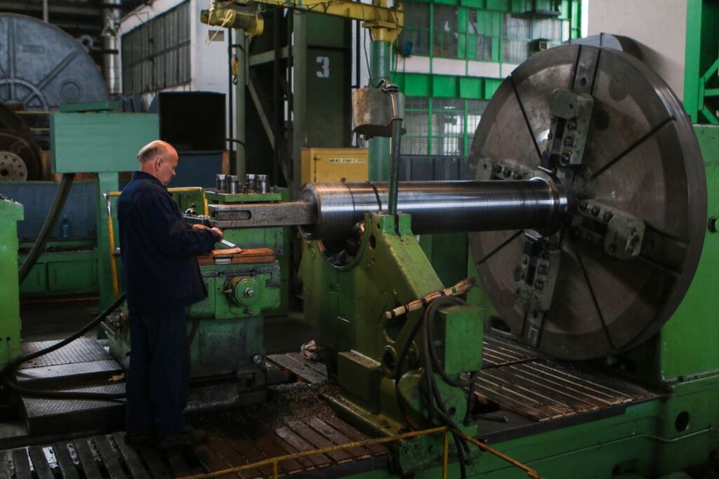 Operator running a large machine on a fabrication shop floor