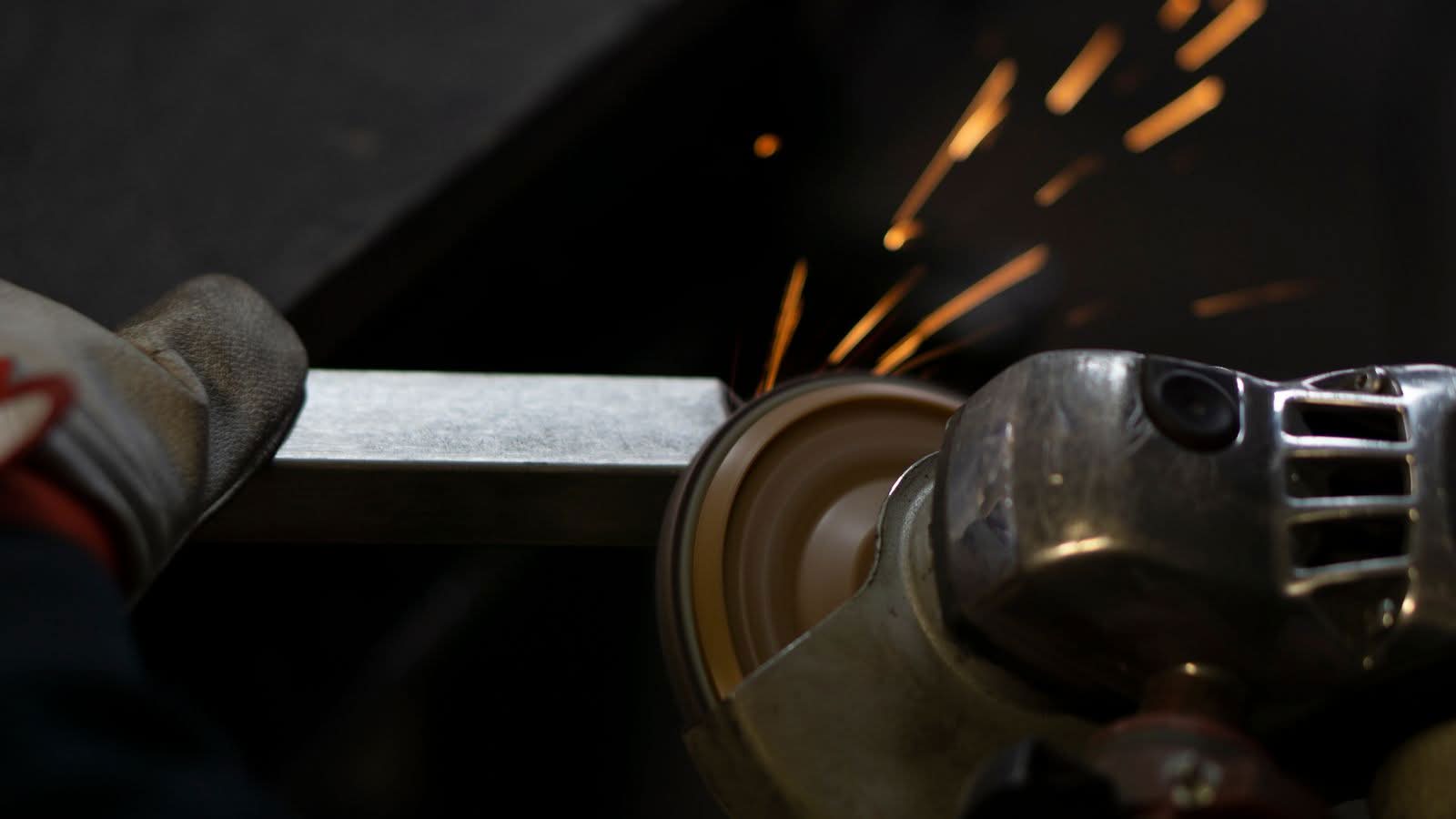 Bright sparks fly as a steel bar is cut in a metal fabrication shop