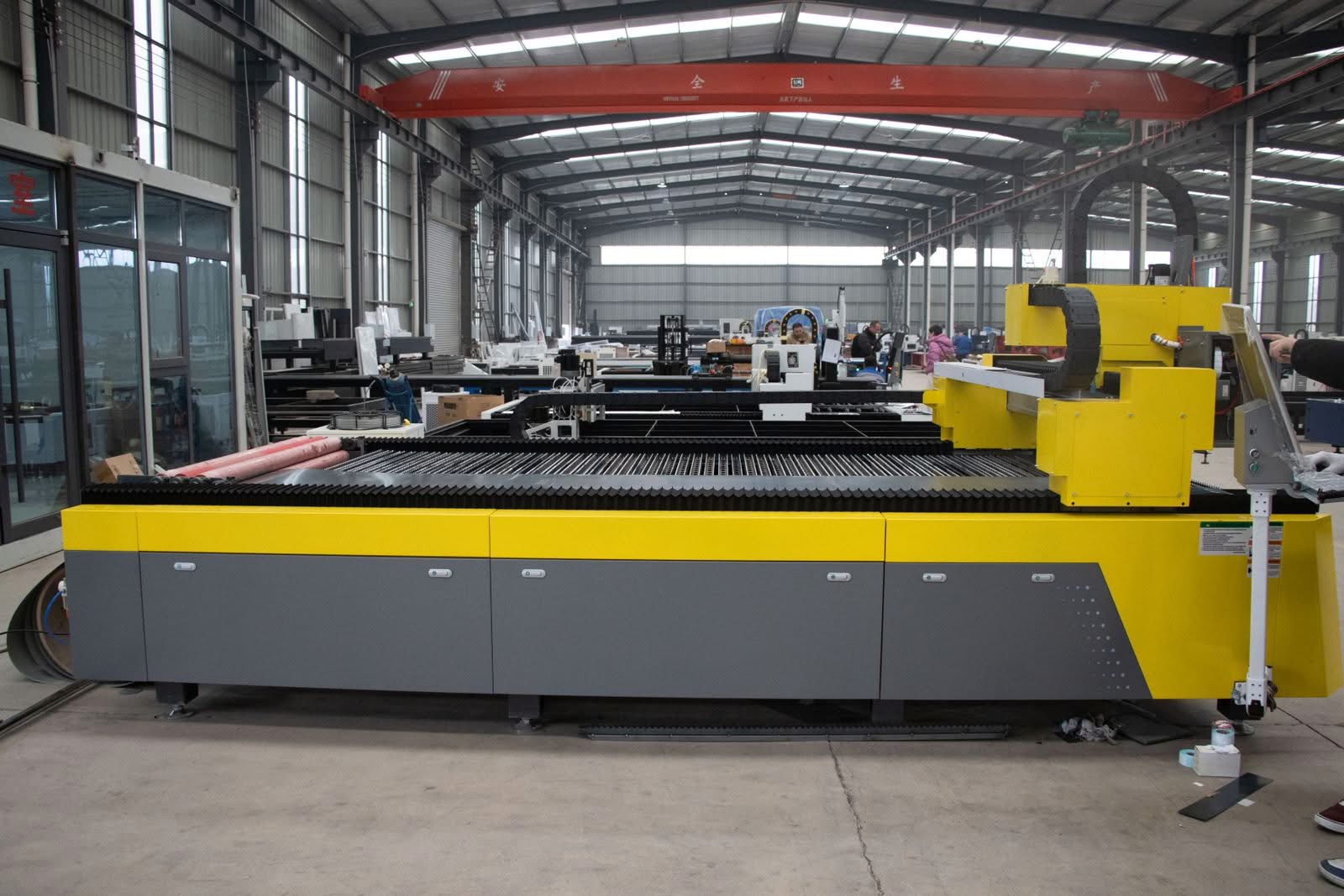 Flat bed fiber laser cutting machine installed on a shop floor in a fabrication facility