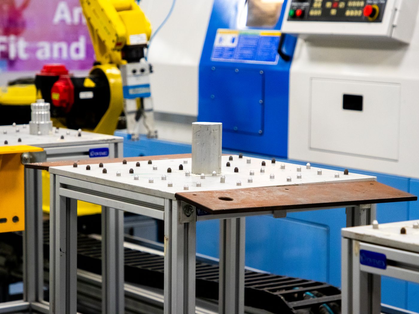 Robotic arm working alongside industrial machinery, one form of automation shops add to a laser cutting cell